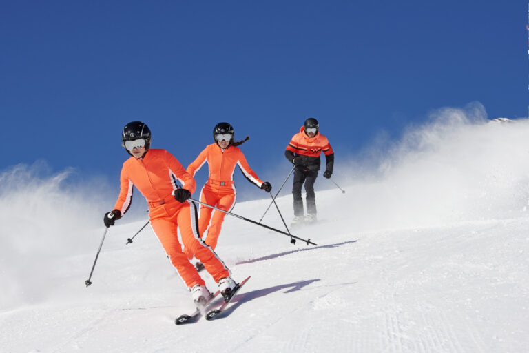 Osoby jeżdzące na nartach w odpowiednuch strojach